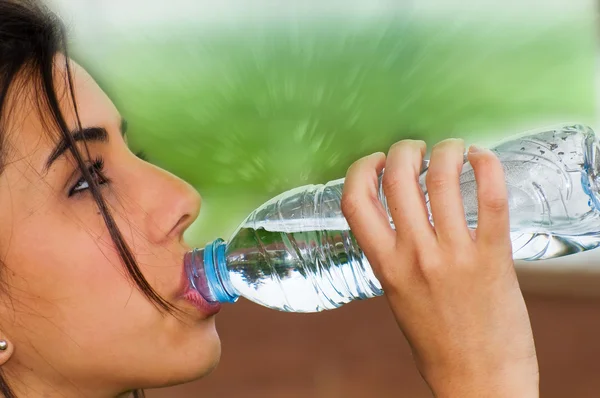 Mladá žena pitnou vodu z láhve po spuštění — Stock fotografie