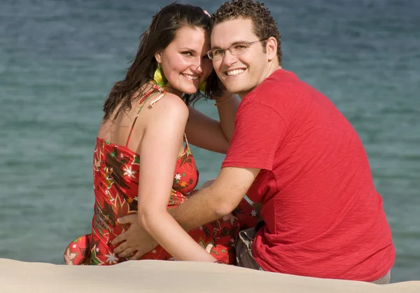 Paret sitter på stranden Stockfoto