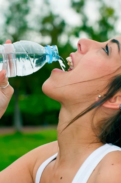 Nuori nainen juomavesi — kuvapankkivalokuva