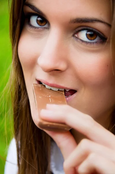 Young woman eating chocolate — Stock Photo, Image