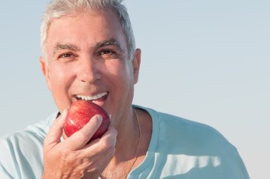 Senior male biting an apple