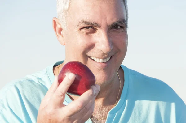 Starší muž drží jablko — Stock fotografie