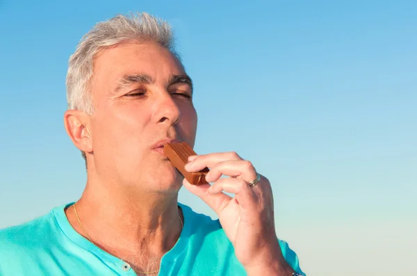 Senior man holding an chocolate — Stock Photo, Image