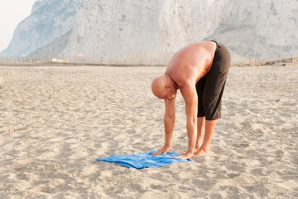 Glad och framgångsrik man utövar yoga Stockbild