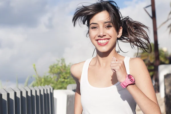Giovane donna sorridente che si esercita in un parco urbano — Foto Stock