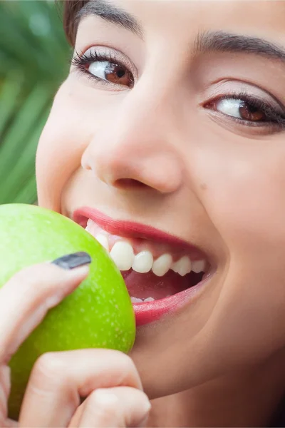 Ung kvinna äter ett äpple Stockbild