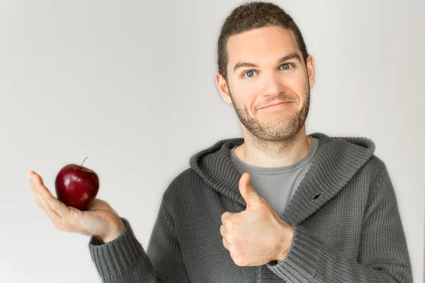 Молодий чоловік з червоним яблуком — стокове фото
