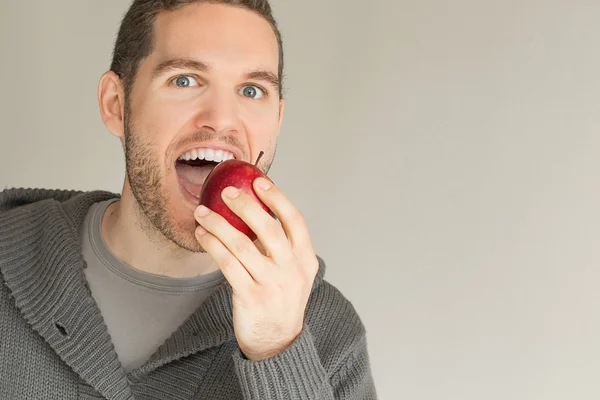 Щасливий чоловік їсть яблуко — стокове фото