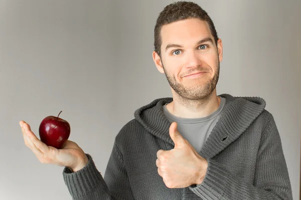 Kırmızı elma ile genç adam — Stok fotoğraf