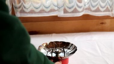 Video Kahve evdeki taşınabilir gaz sobasının üzerinde bir kafeste demlenir.