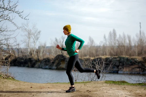 Orta yaşlı bir kadın güneşli bir günde ormanda koşar. Sağlıklı bir yaşam tarzı. Çok koyu pembe, antika fuşya ve eski lavanta renkleriyle fitness dekoratif pankart tasarımı. akışkan dalgalar ve eğrilerle dinamik eğri çizgiler