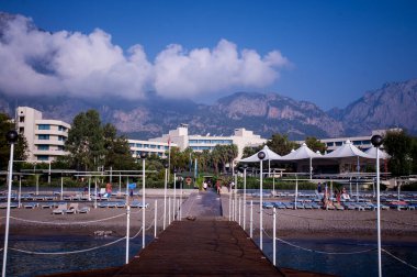 Deniz kıyısında. Hava açık. Yaz. Dinlen. Seyahatler. kumsal, palmiye ağaçları ve dağlar