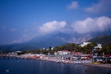 Deniz kıyısında. Hava açık. Yaz. Dinlen. Seyahatler. kumsal, palmiye ağaçları ve dağlar