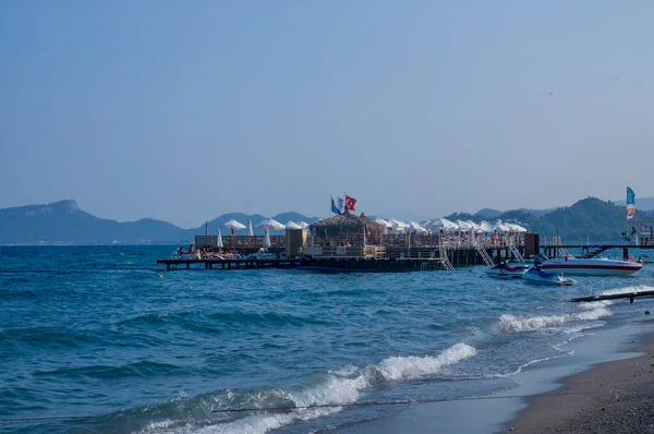Öğleden sonra dağları olan taştan deniz kıyıları. Turizm. Seyahatler. dinlenme