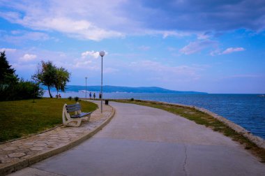 Yazın bulutlu havada deniz kıyısında asfalt yol. Seyahatler. Turizm. Doğu Avrupa 'nın doğası. Bulgaristan
