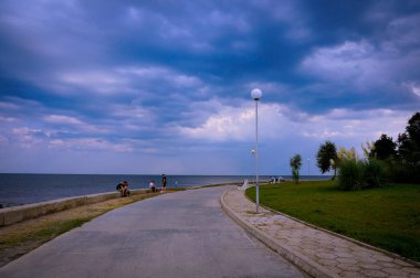 Yazın bulutlu havada deniz kıyısında asfalt yol. Seyahatler. Turizm. Doğu Avrupa 'nın doğası. Bulgaristan