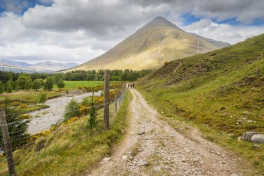 19.05.2022 Tyndrum, Stirling, İskoçya, İngiltere. Batı Highland yolunda yürüyen üç aylak ve bir köpek.