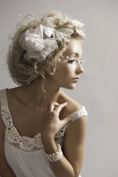 Beautiful petite blonde woman in white fantasy makeup and clothes — Stock Photo, Image