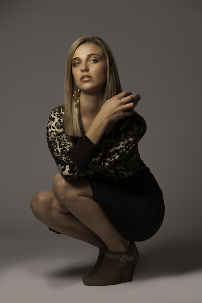 Beautiful blonde woman wearing animal print dress and suede shoes