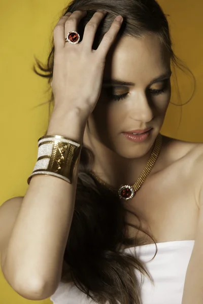 Portrait of brunette woman looking down wearing jewels — Stock Photo, Image