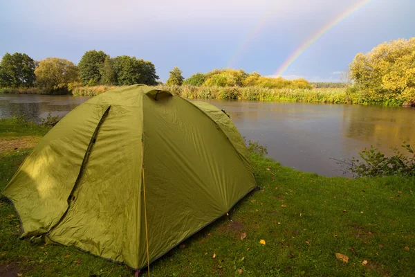 Tenda verde piantata sulla riva di un lago . — Foto Stock