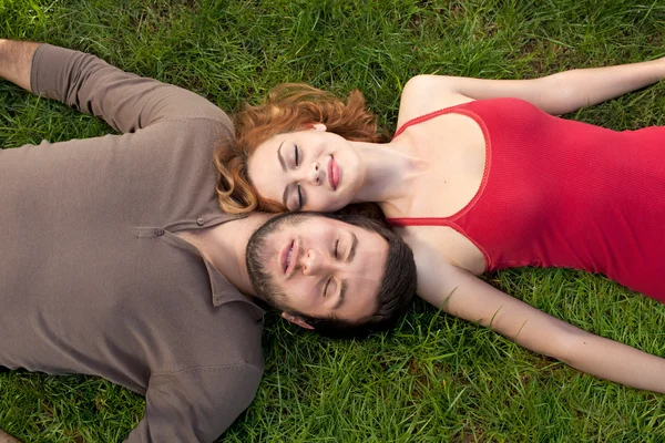 Jong koppel slapen op groen gras — Stockfoto