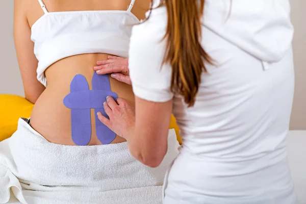 Chiropractor applying three kinesiology tapes. — Stock Photo, Image