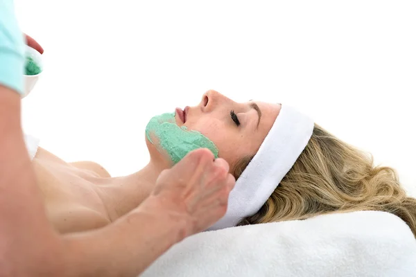 Esteticista aplicando máscara facial na mulher bonita . — Fotografia de Stock