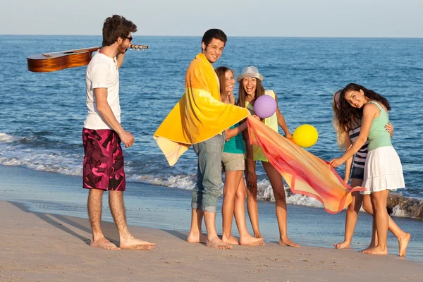 Grupp av unga människor njuter av beach party med gitarr och ballo — Stockfoto