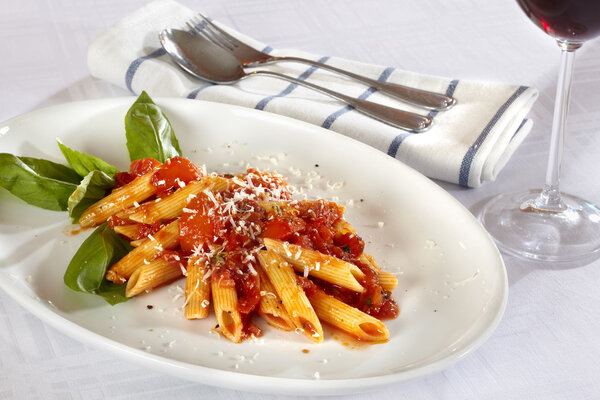 Pasta on white plate with tomato sauce