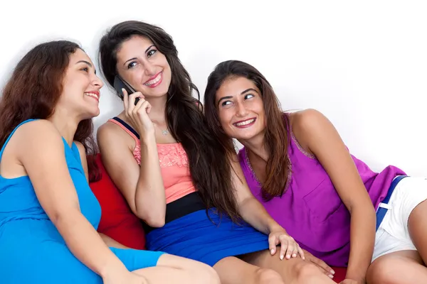 Trois belles jeunes femmes avec un téléphone portable intelligent . — Photo