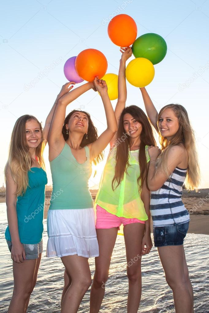 Four happy girls on the beach