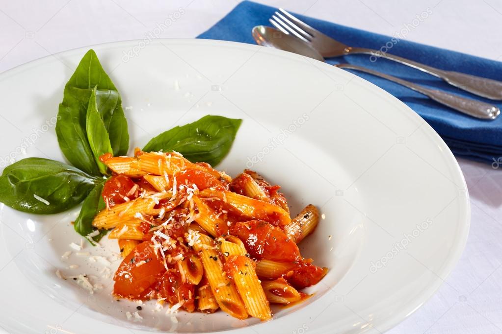 Pasta on white plate with tomato sauce