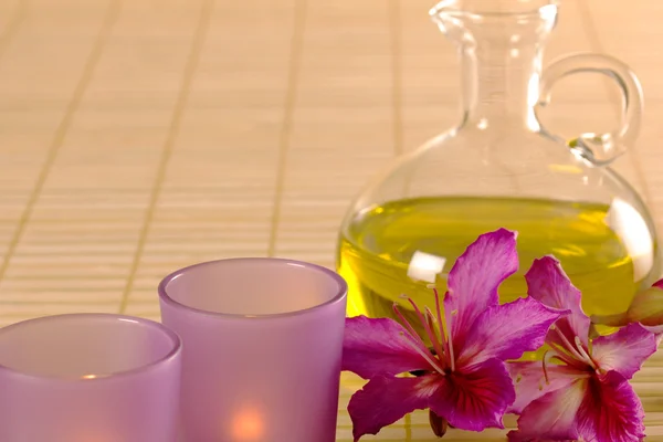 Essential oil, candles and purple flowers. — Stock Photo, Image