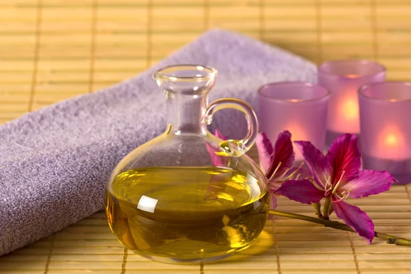 Etheric oil, candles and purple towel. — Stock Photo, Image