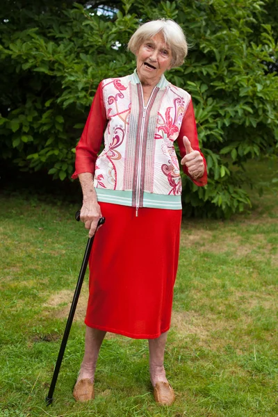 Elderly woman standing with her walking stick — Stock Photo, Image