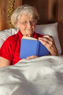 üst düzey kadın yatakta kitap okuma