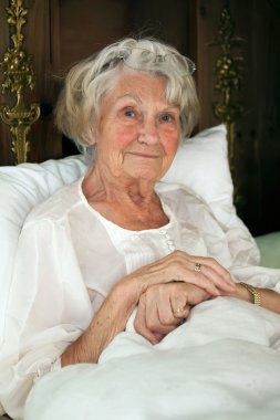 Senior woman resting in bed clipart