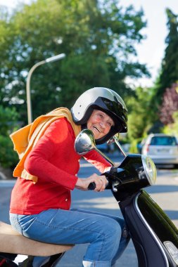 Canlı yaşlı kadın bir scooter sürme.