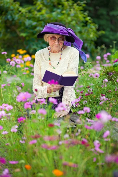 Elegante donna anziana lettura all'aperto — Foto Stock