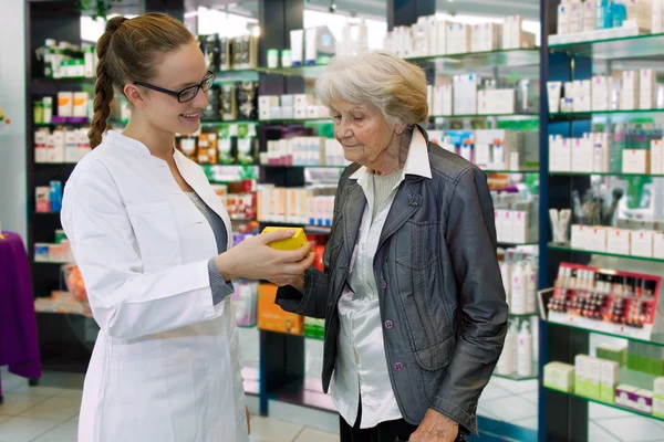 Farmacêutico que aconselha a paciente idosa — Fotografia de Stock