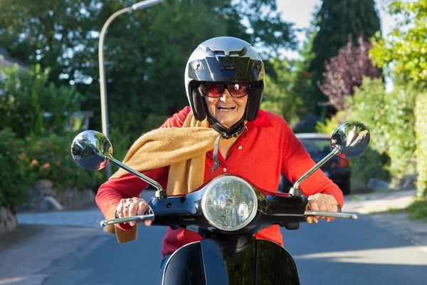 Üst düzey Bayan bir scooter sürme. — Stok fotoğraf