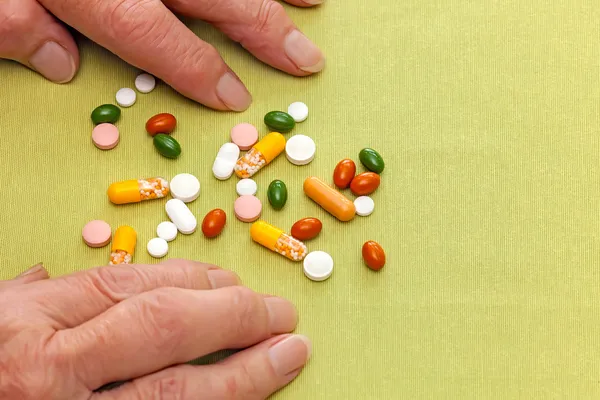 Hands of an old woman confused by her medication — Stock Photo, Image