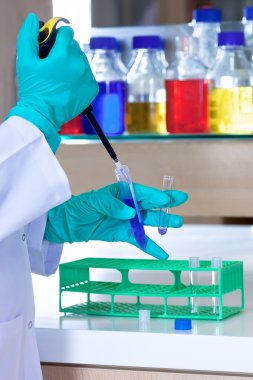 eldivenli bir pipet kullanarak Laboratuar teknisyeni. 