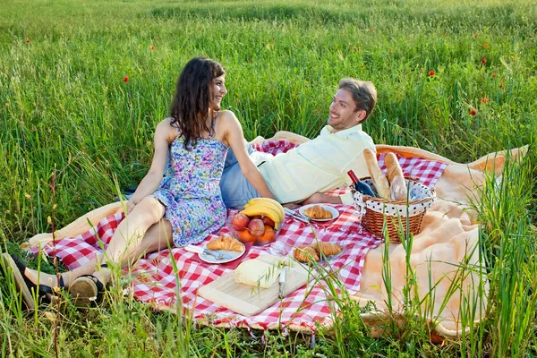 Couple chatting on checked rug — Stock Photo, Image