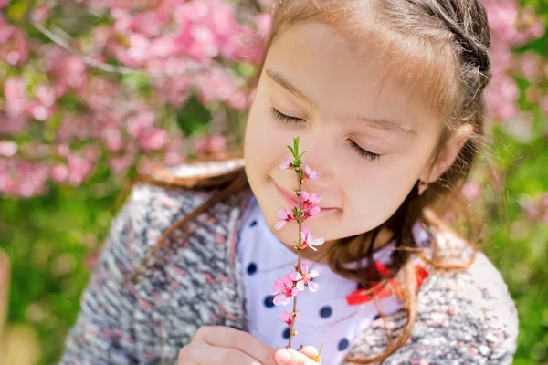 Little girl snuff flowers — Stock Photo, Image