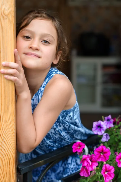 Girl standing on the terrace with flowers — Stock Photo, Image