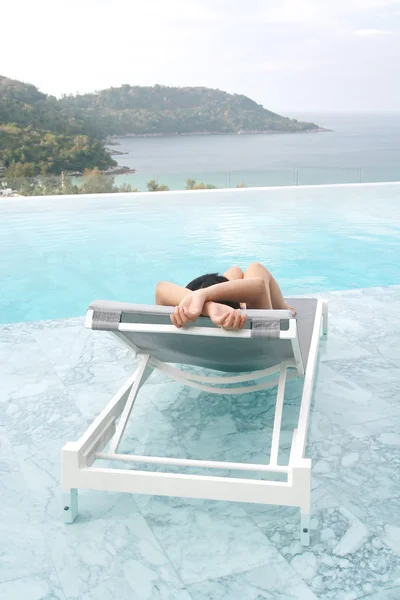 Tourist sleep on deckchair and swimming pool — Stock Photo, Image