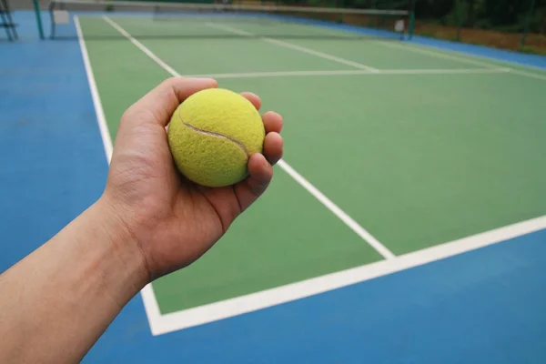 Tennis bold på spiller hånd - Stock-foto