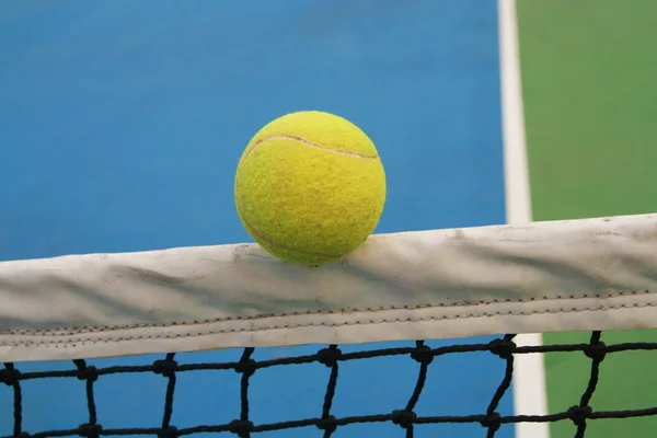 Tennis ball on net — Stock Photo, Image